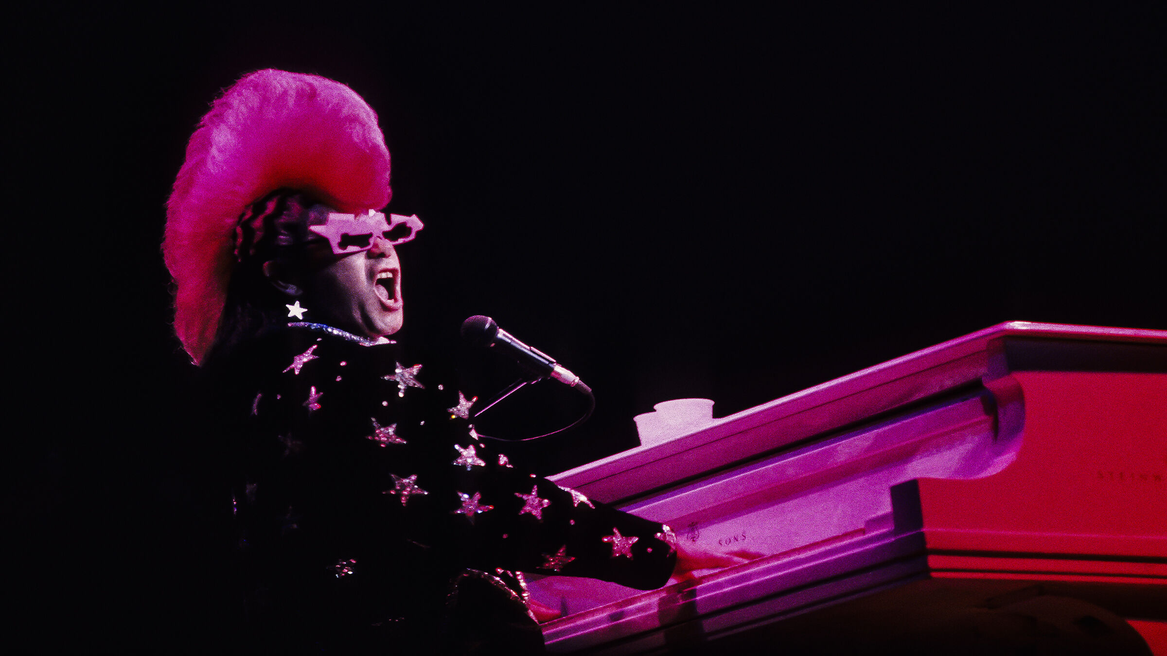 Elton John vid ett piano på en scen