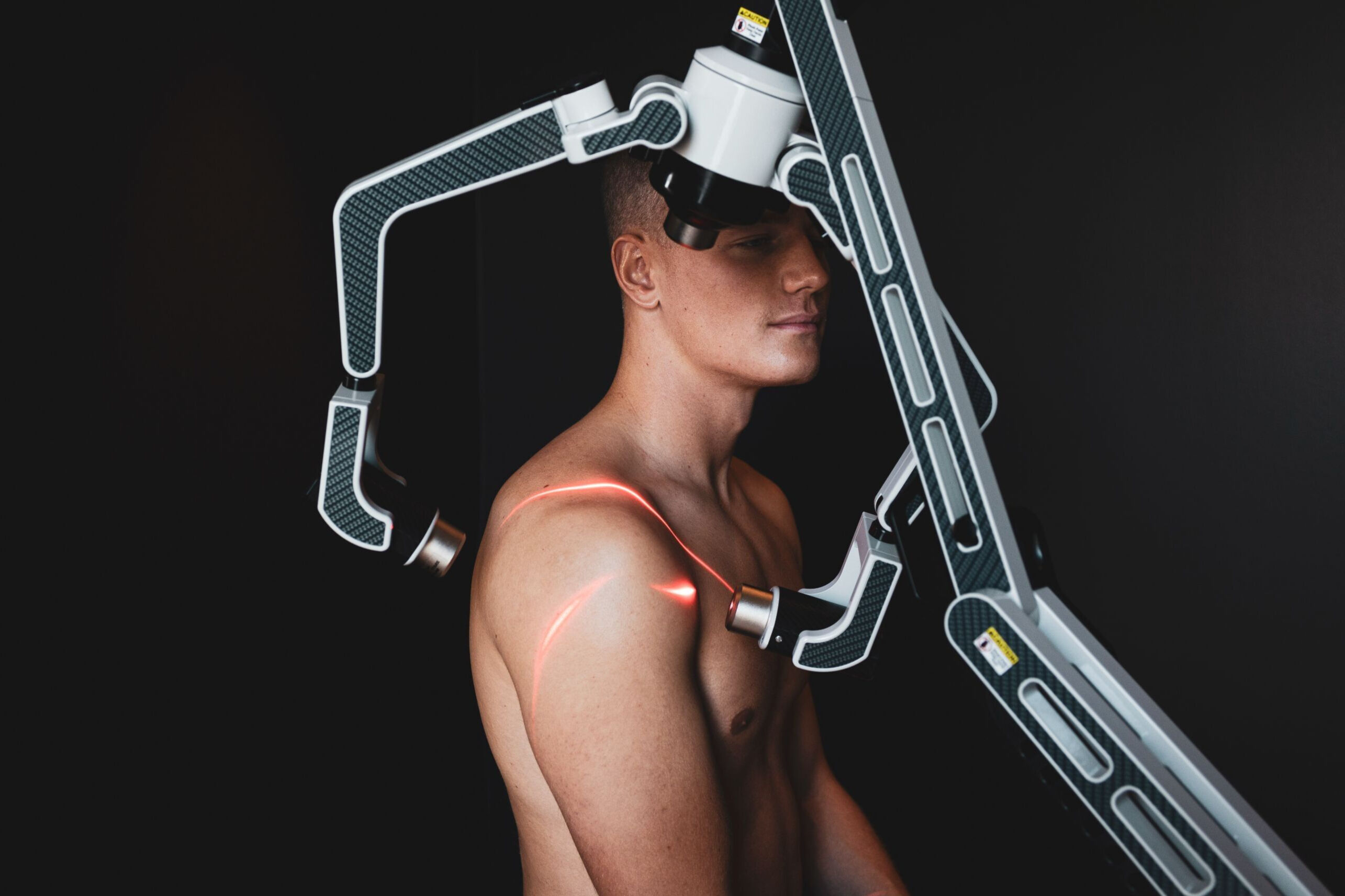 Man som behandlas med röd laser på axeln