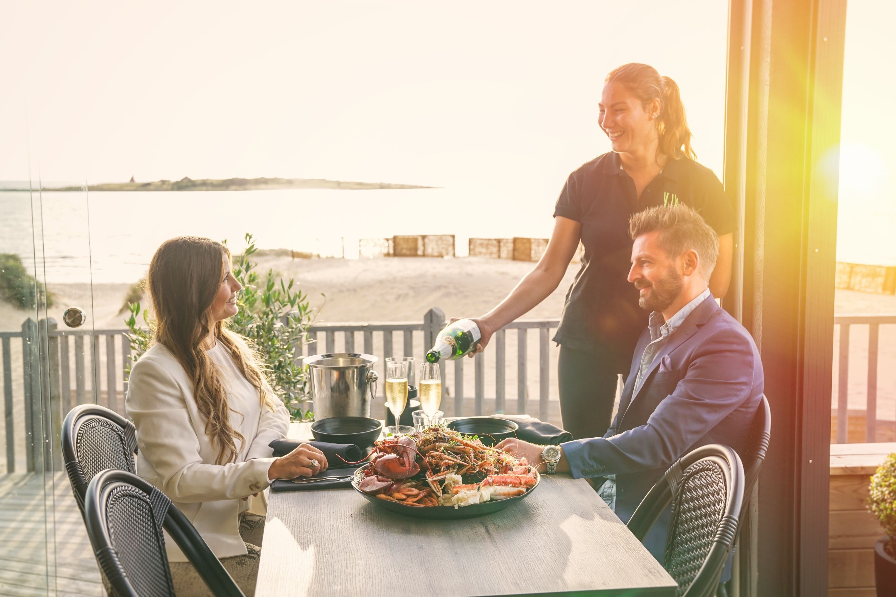 Servitör som serverar vin till en man och en kvinna