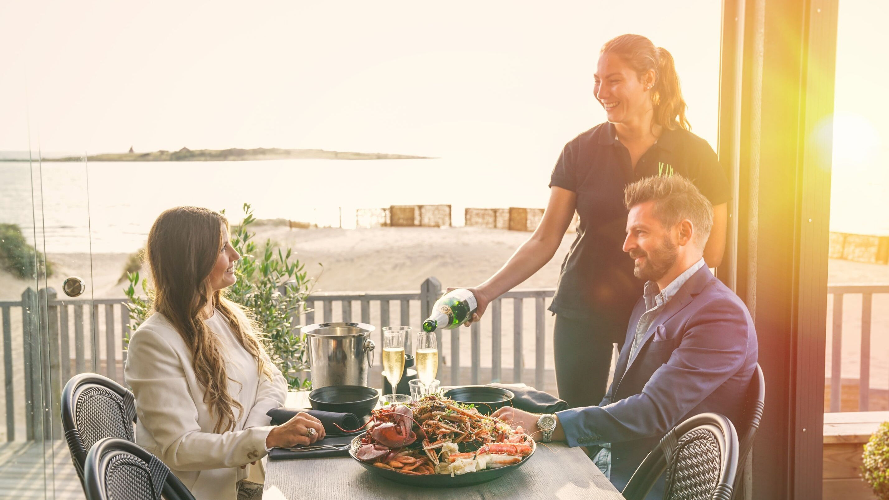 Servitör som serverar vin till en man och en kvinna