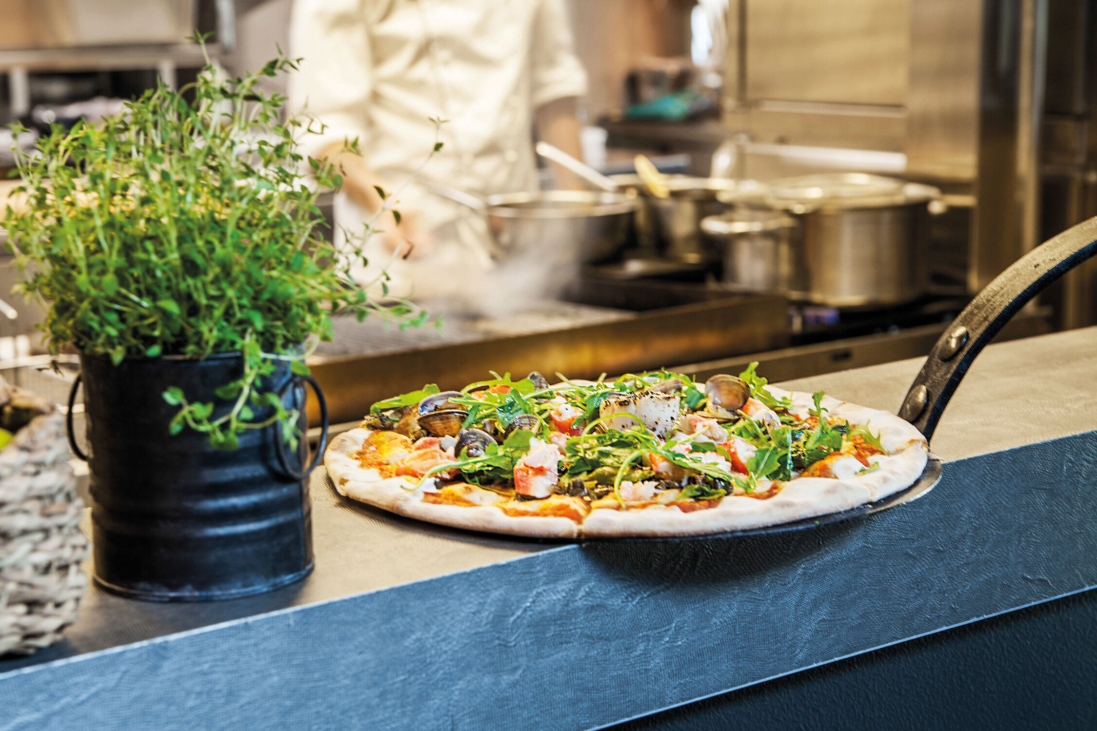 En kock bakar pizza.