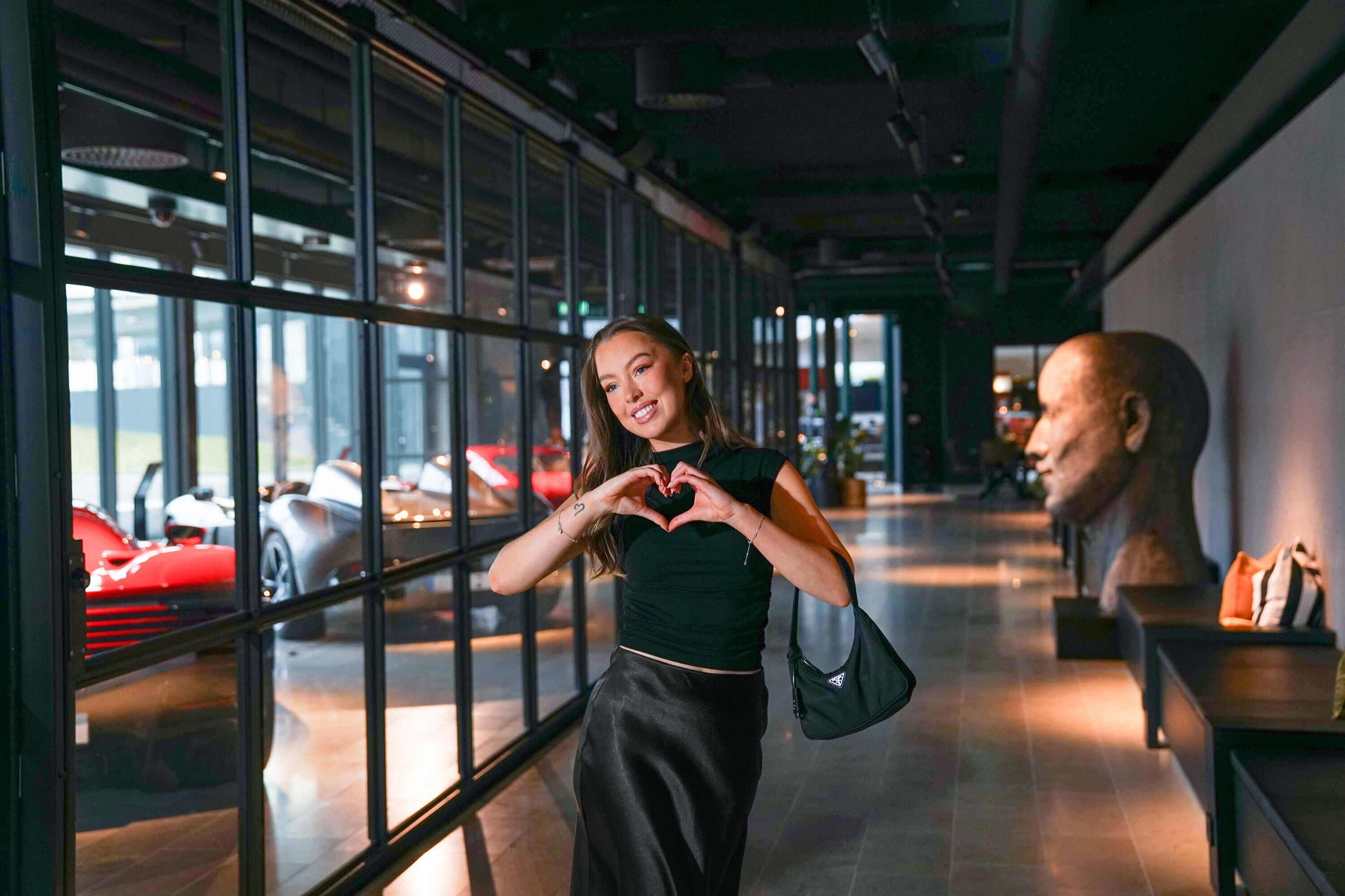 Tjej gör ett hjärta utanför Hotel Tylösands Ferrariutställning