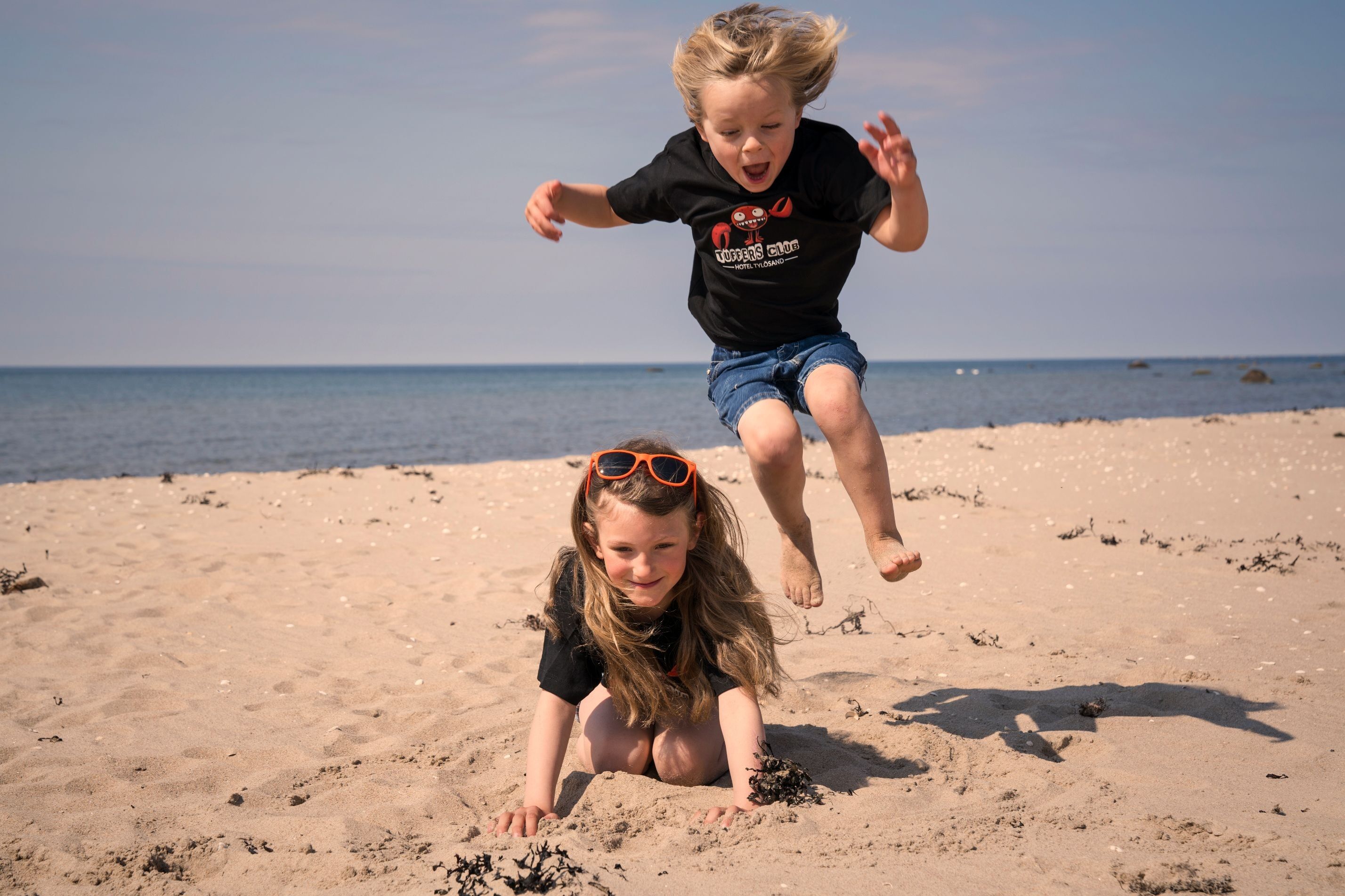 Två lekande barn på stranden i Tylösand