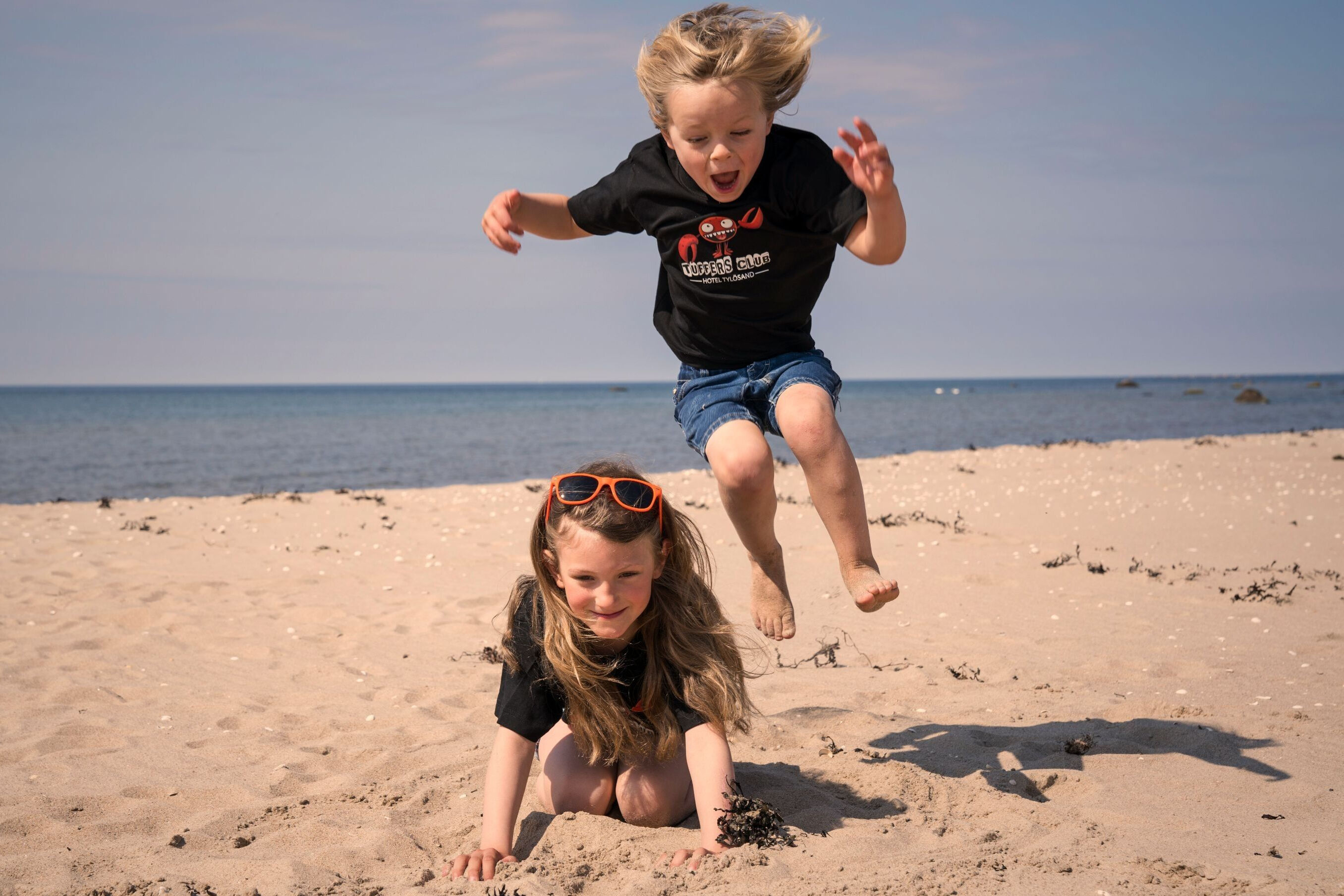 Två lekande barn på stranden i Tylösand.