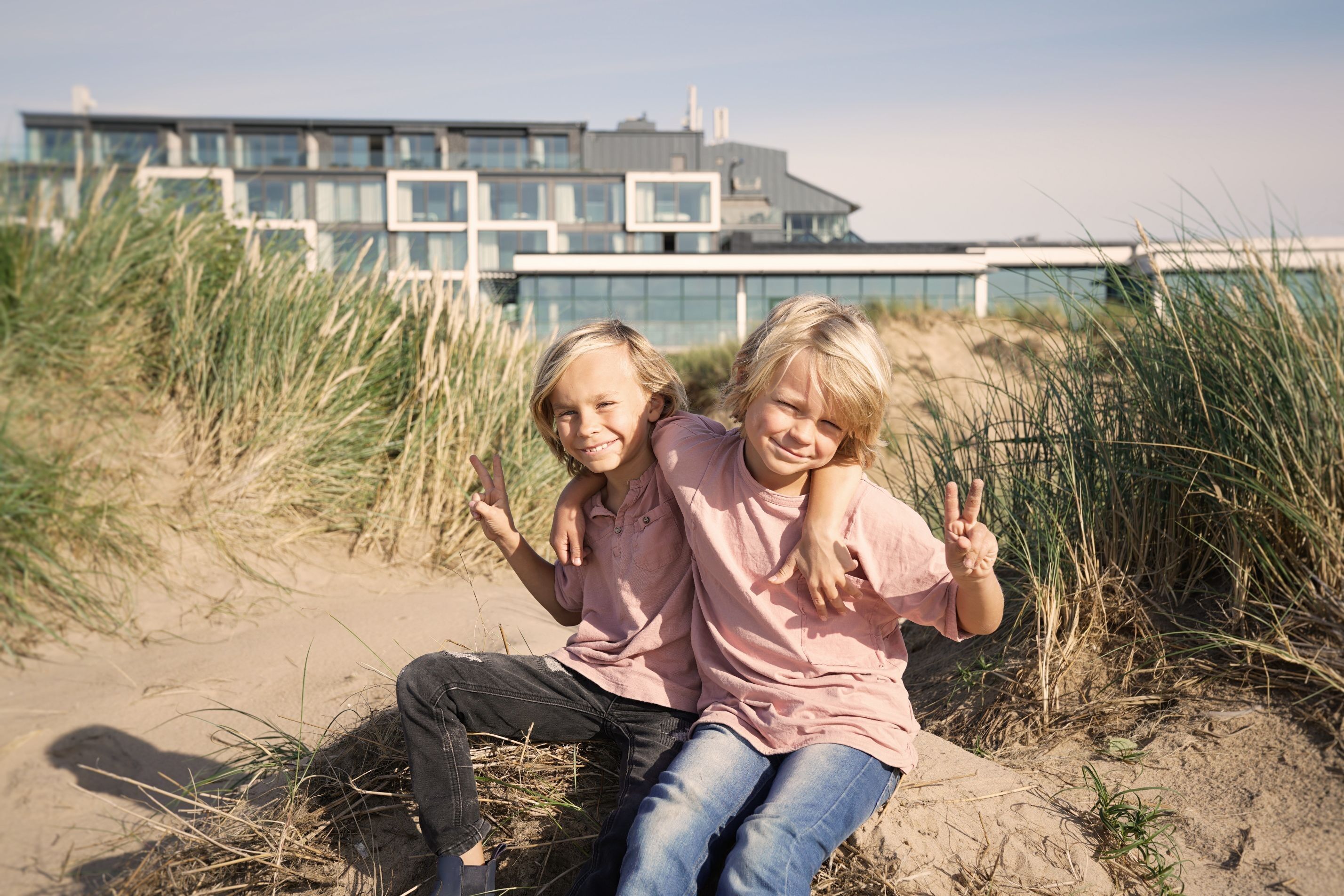 Två pojkar som sitter på stranden i Tylösand