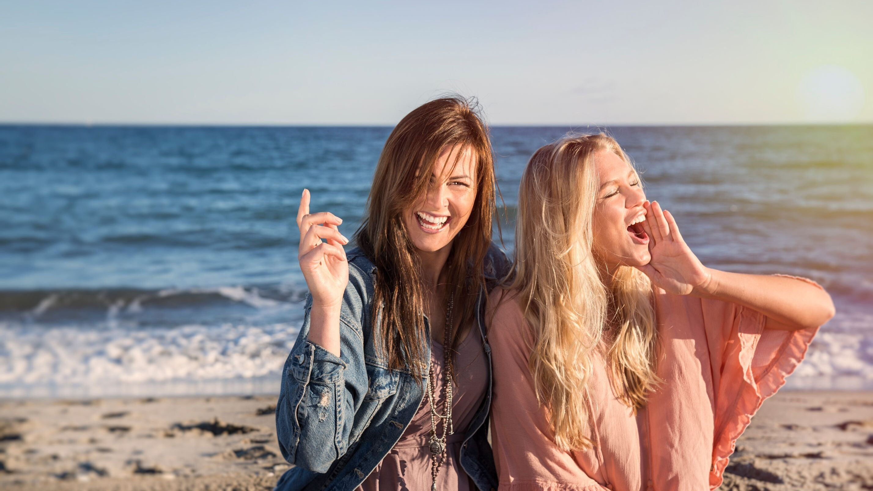Två glada tjejer på stranden i Tylösand