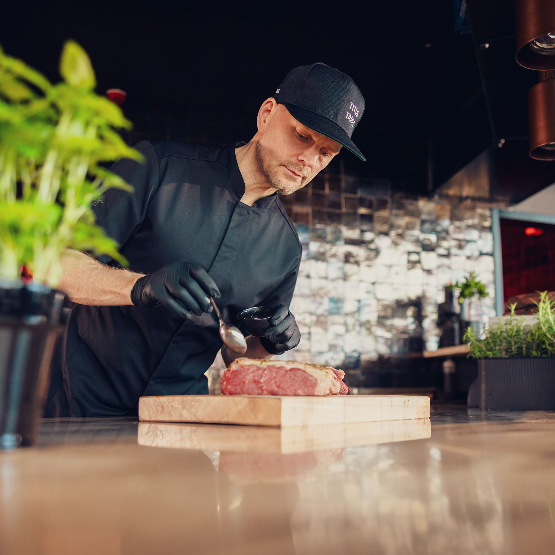 Kock som tillagar kött på Titus Tapas.