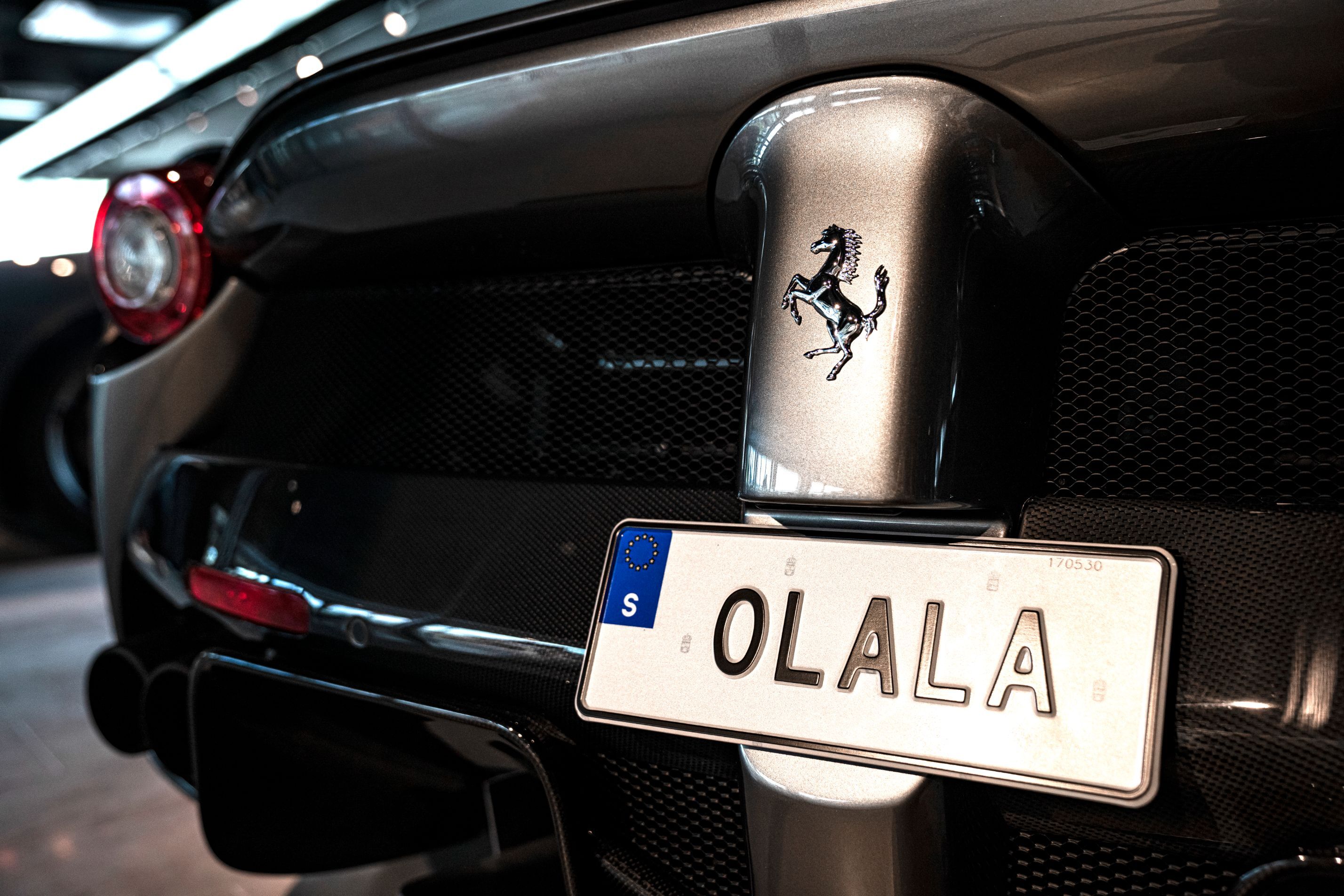 Närbild av en registreringsskylt med texten "OLALA" på en Ferra