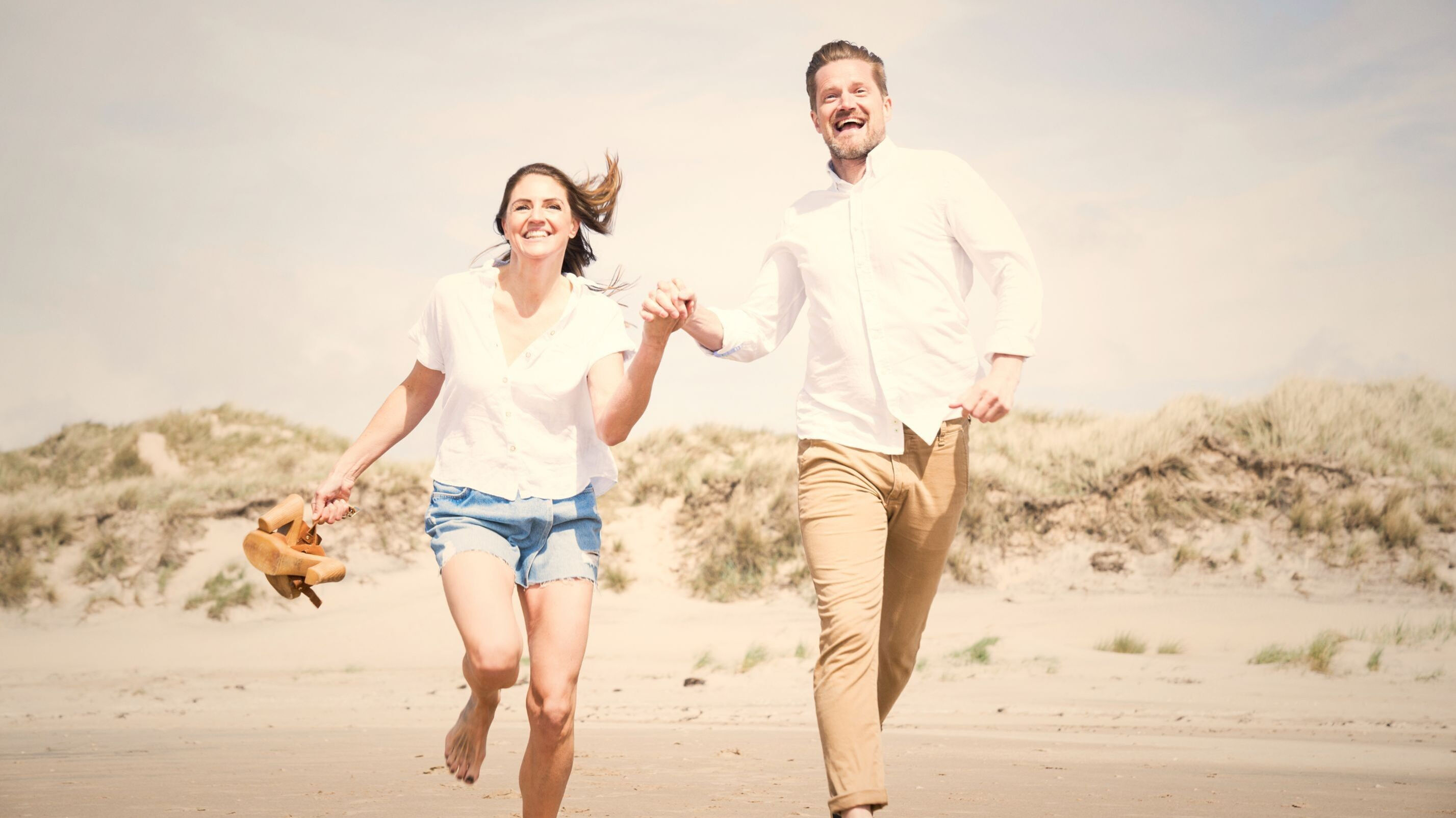 Ett par som springer på stranden i Tylösand