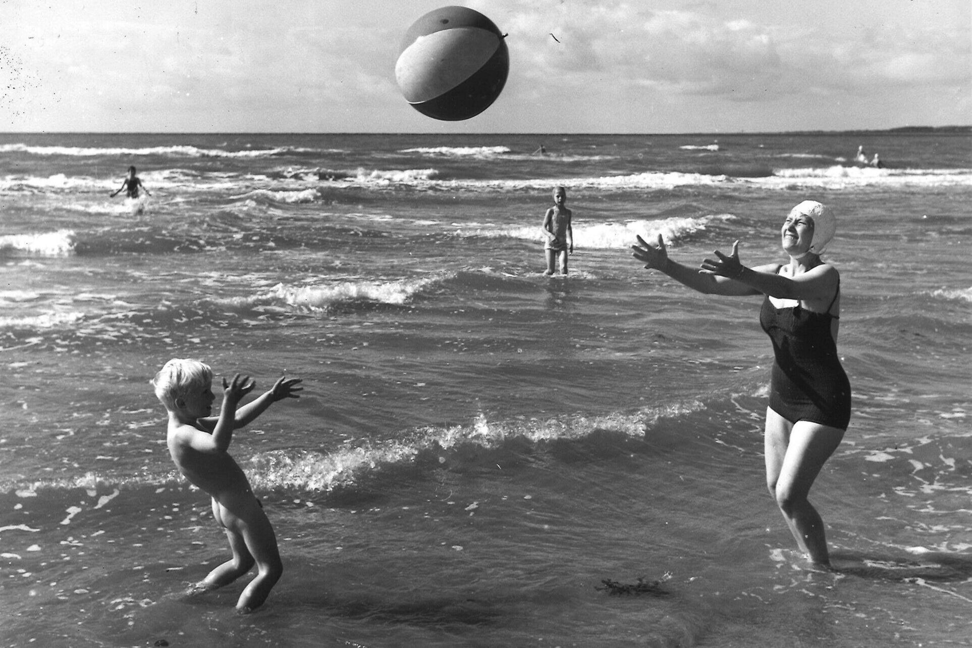 Mamma och son kastar badboll i vattenbrynet Tylösand 1920-talet